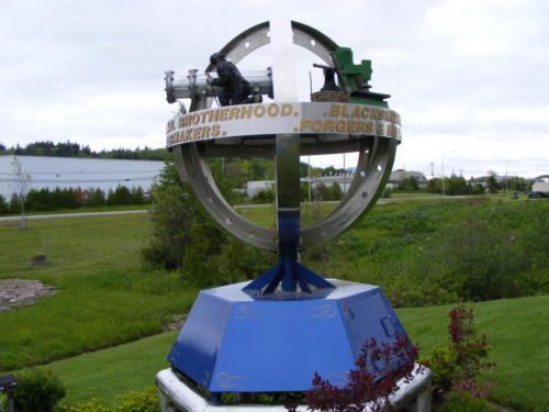 This exceptional work of art sits in front of the Boilermakers Training Centre on King William Road, Saint John West. It depicts the logo of the Boilermakers, brought into three dimensions. The work was done in 2003 by a member of the Boilermakers union, Abel Caissie, with the help of this son Reni and his friend Robert Hache. It is made of wood and stainless steel and rotates on its base.